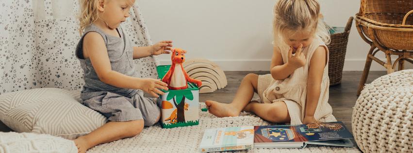 two toddlers playing puzzles books musical hop out mizzie